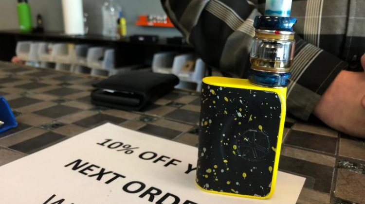 An "open tank" e-cigarettes sits on the counter at Mason Odle's vape store, Just Vapor. These larger, open tank systems are exempt from FDA regulations on flavors. - Carter Barrett/Side Effects Public Media