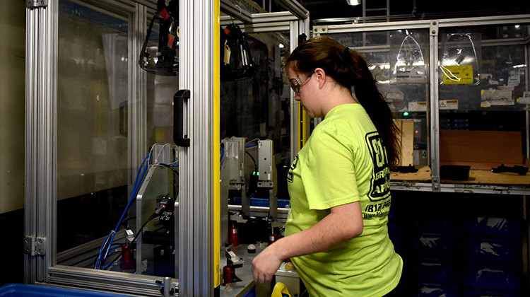 A worker at a factory in North Vernon, Indiana, works with a plastics manufacturing robot. - Justin Hicks/IPB News