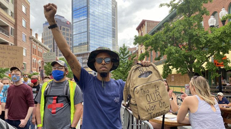Cory Wise marches with protesters along Massachusetts Avenue on Wednesday, June 10. His bag says “this is our war on terror.” - Darian Benson/Side Effects Public Media