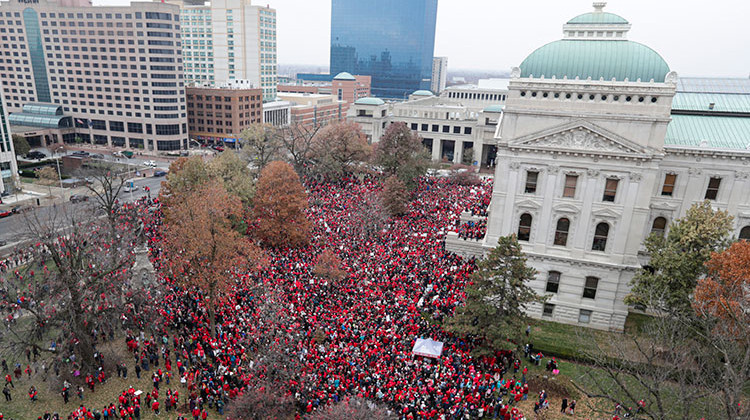 Thousands of Indiana teachers wearing red surround the Statehouse in Indianapolis, Tuesday, Nov. 19, 2019 for a rally calling for further increasing teacher pay in the biggest such protest in the state amid a wave of educator activism across the country. Teacher unions says about half of Indiana's nearly 300 school districts are closed while their teachers attend Tuesday's rally while legislators gather for 2020 session organization meetings. - AP Photo/Michael Conroy