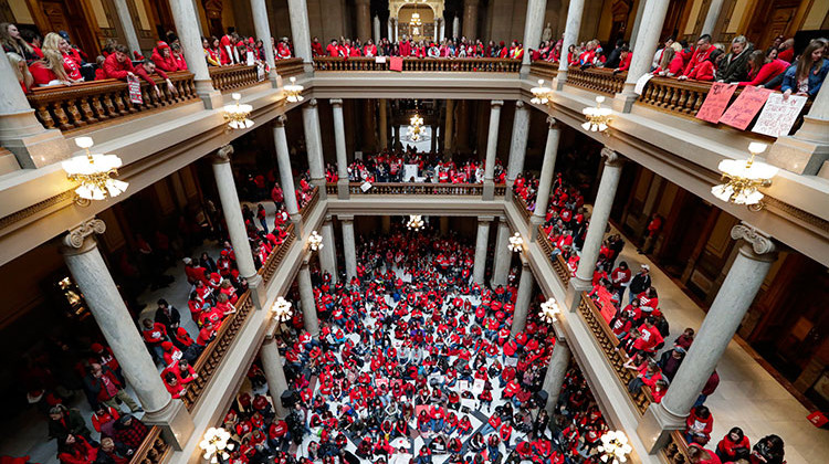 Thousands of Indiana teachers wearing red hold rally at the Statehouse in Indianapolis, Tuesday, Nov. 19, 2019, calling for further increasing teacher pay in the biggest such protest in the state amid a wave of educator activism across the country. Teacher unions says about half of Indiana's nearly 300 school districts are closed while their teachers attend Tuesday's rally while legislators gather for 2020 session organization meetings. - AP Photo/Michael Conroy