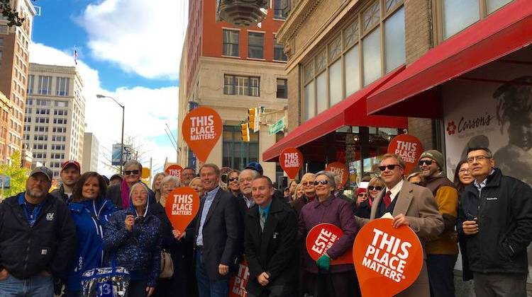 Indianapolis Mayor Joe Hogsett, center, poses for a group photo with those who came downtown Sunday, Nov. 20, 2016 to witness the restart of the L.S. Ayres clock. - Michelle Johnson / WFYI News