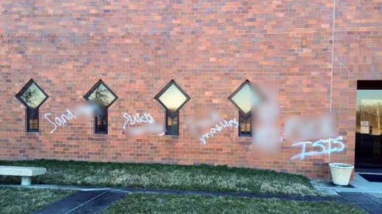 Security video shows three people spray painting these vulgar anti-Muslim phrases on a wall of the Islamic Society of North America. WFYI has blurred the obscenities. - Courtesy Islamic Society of North America via Facebook.