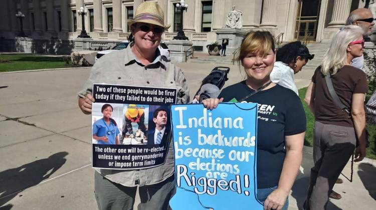 Two advocates hold up their signs in front of the federal courthouse in Indianapolis. - Lauren Chapman/IPB News