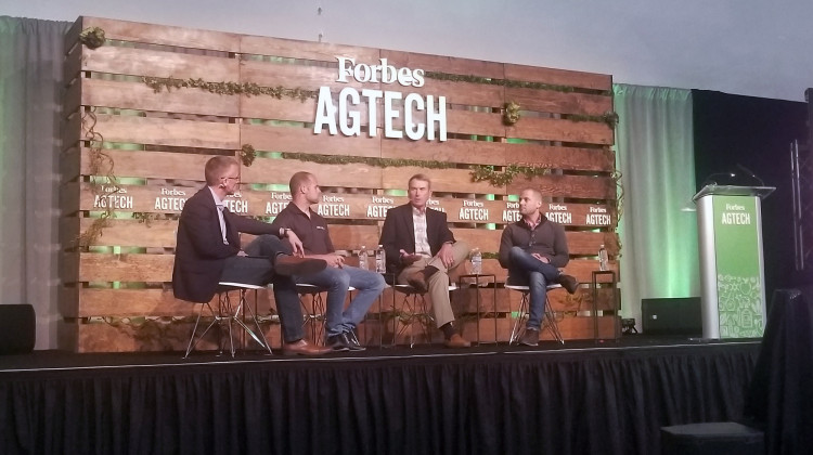 (From left to right) Reynolds Farm Equipment CEO Mitch Frazier talks with panelists AgNext CEO Troy Fiechter, farmer Jim Kline, and Taranis head of marketing Alex Whitley during Forbes AgTech Summit in Indianapolis. - Samantha Horton/IPB News