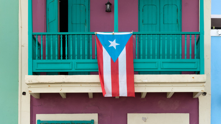The flag of Puerto Rico hanging from a balcony. - Lorie Shaull/Flickr