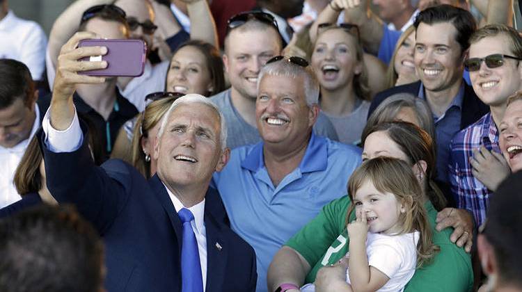 Republican vice presidential nominee Gov. Mike Pence of Indiana takes photos with supporters during a Welcome Home Rally on Saturday in Zionsville, Ind. Pence is a passionate advocate for school choice and state control over federal oversight. - Darron Cummings/AP
