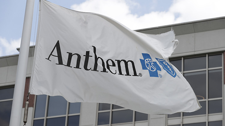 FILE - In this May 14, 2019, file photo a flag flies the outside of the corporate headquarters building of health insurance company Anthem is shown in Indianapolis. Anthem’s second-quarter profit doubled to nearly $2.3 billion, as a pandemic-induced drop in claims and a new business pushed the Blue Cross-Blue Shield insurer’s earnings past expectations.  But the nation’s second-largest insurer left its 2020 earnings forecast unchanged, following a pattern established by its com - AP Photo/Michael Conroy, File