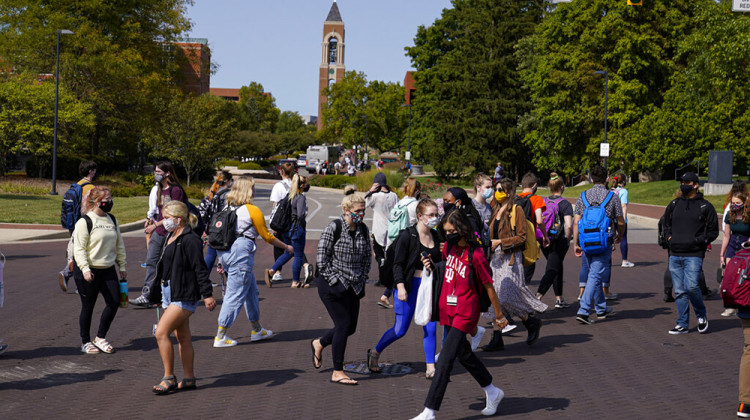 Masked students cross an intersection on the campus of Ball State University in Muncie, Ind., Thursday, Sept. 10, 2020. College towns across the U.S. have emerged as coronavirus hot spots in recent weeks as schools struggle to contain the virus. - AP Photo/Michael Conroy