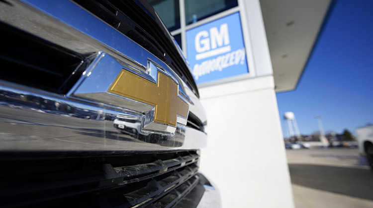 The company logo shines off the grille of an unsold 2022 Silverado pickup truck as it sits in an empty storage lot at a Chevrolet dealership Sunday, Feb. 27, 2022, in Englewood, Colo. - AP Photo/David Zalubowski
