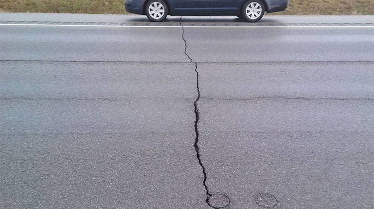 Cracking in asphalt on S.R. 25 in Cass County. INDOT says Fort Wayne, Ind.-based Brooks Construction Co. must remove and replace the three-mile stretch of highway or repay the $5 million the agency paid the company. - Indiana Department of Transporation