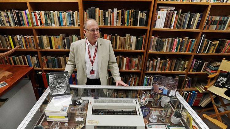 In this Thursday, April 12, 2018, photo, Center for Ray Bradbury Studies director Jonathan Eller stands behind Ray Bradbury's basement office recreation at IUPUI's Center for Ray Bradbury Studies, in Indianapolis. The display includes the author's desk, where Mr. Bradbury worked in his Los Angeles home for nearly half a century. - AP Photo/Darron Cummings