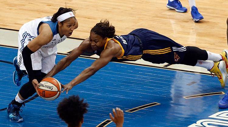 Indiana Fever forward Tamika Catchings dives for the ball as Minnesota Lynx forward Maya Moore dribbles in the first half of Game 5 of the WNBA basketball finals, Wednesday in Minneapolis. - AP Photo/Stacy Bengs