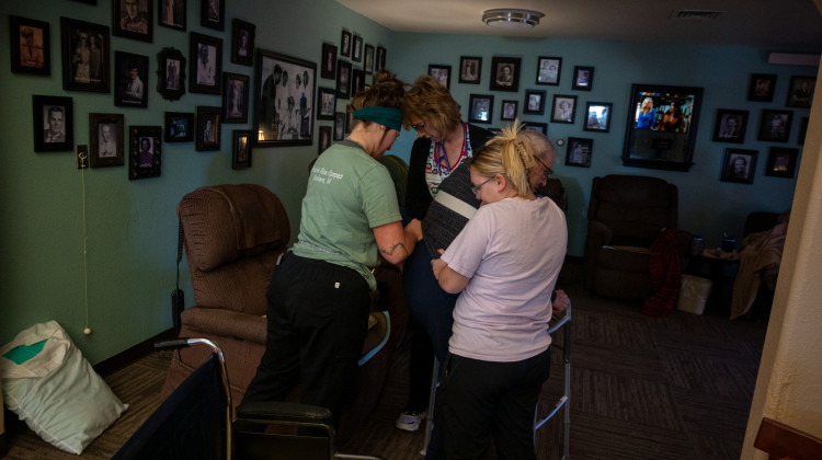 Employees at the Prairie View Nursing Home in Sanborn, Iowa, help a resident into a chair following lunch. - Natalie Krebs / Side Effects Public Media