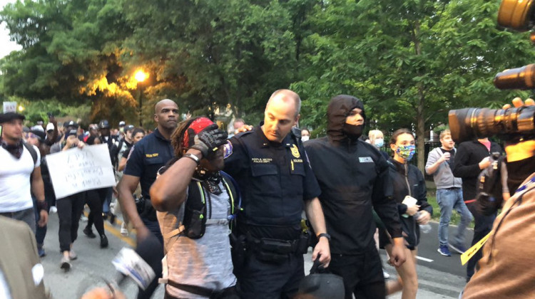 IMPD Lt. Andrew Rolinson and one of the march leaders, Malik Muhammad, walk south down Meridian Street, away from the governor's residence. - Eric Weddle/WFYI News