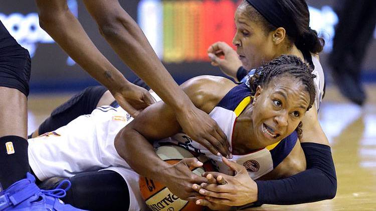 Indiana Fever's Tamika Catchings, front, tries to call a time out as she scrambles on the floor with Minnesota Lynx's Maya Moore in the second half of Game 4 of the WNBA Finals basketball series, in Indianapolis on Sunday. - AP Photo/Michael Conroy