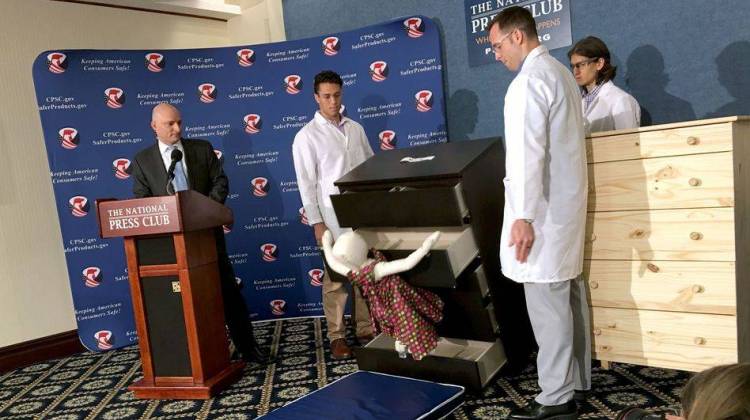 Elliot Kaye (left), chairman of the Consumer Product Safety Commission, and CPSC employees watch as an IKEA Malm model chest of drawers falls on a 28-pound dummy during a demonstration Tuesday at the National Press Club in Washington, D.C.