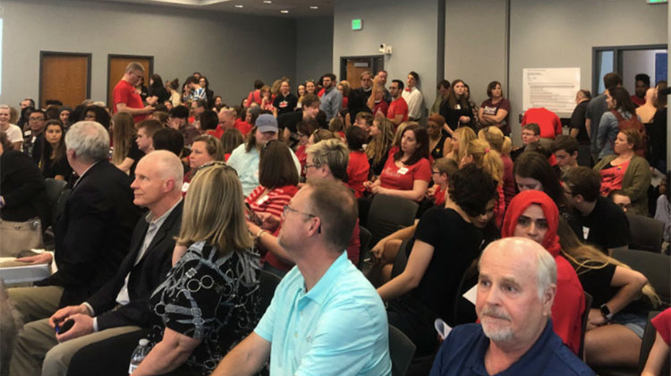Hundreds of people in red t-shirts filled the board room, a hallway, and overflow room at the HSE central services building Wednesday night. - Carter Barrett/WFYI