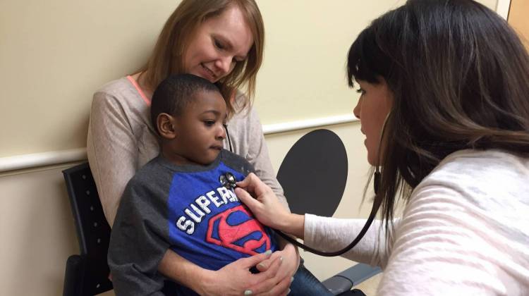 Jen Atkinson holds her son, Daniel, as his nurse practitioner, Amy Realbuto, checks his heart and lungs. - Michelle Faust