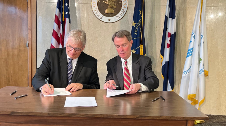 HUD Principal Deputy Assistant Secretary Richard Monocchio and Indianapolis Mayor Joe Hogsett sign the cooperative agreement. (Jill Sheridan WFYI)