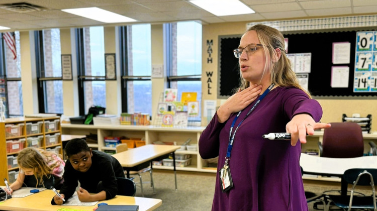 Second-grade teacher Morgan O'Dell holds her fingers to her throat to show her students how to feel whether they are using their vocal cords at Thomas Miller Elementary School in Lafayette on Tuesday, Dec. 4, 2023.  - Dylan Peers McCoy/WFYI
