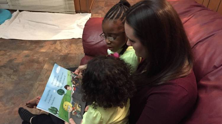Stephanie Zielinski reads to her two adopted daughters. - Michelle Faust