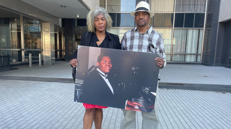 Gladys and Herman Whitfield Jr. hold a photo of their son Herman. - Katrina Pross/WFYI News file photo