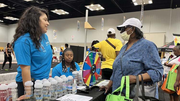 Visitors to the Black and Minority Health Fair in Indianapolis interact with volunteers at the Eskenazi Health booth on Saturday, July 16. - Farah Yousry/WFYI