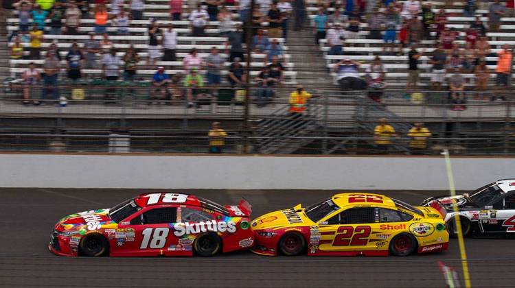 Kyle Busch (18) used a push from Joey Lagano (29) to take the lead on a restart in the closing laps of the Brickyard 400. - Doug Jaggers