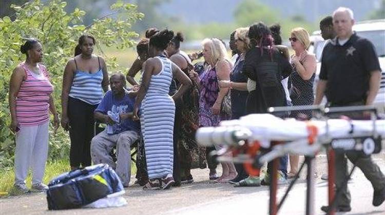 Members of St. Jude Family Worship Center gather off the side of the road after their church bus crashed on Interstate 70 in Greenfield, Ind., Tuesday, July 28, 2015. Indiana State Police Capt. David Bursten says the bus was traveling from northwestern Indiana when it crashed in eastbound lanes about 20 miles east of Indianapolis. - The Associated Press