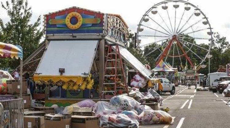 In this photo taken Wednesday, Aug. 5, 2015, midway staff set up games and rides in preparation for the Indiana State Fair in Indianapolis. The state fair starts its 17-day run on Friday with its annual complement of thrill rides and unusual foods, along with numerous events marking "The Year of the Farmer. " -  Michelle Pemberton/The Indianapolis Star via The Associated Press