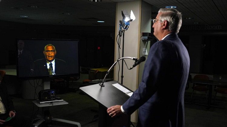 Indiana Republican Gov. Eric Holcomb listens to Democrat Woody Myers on a monitor as he participates in the Indiana Gubernatorial debate with Democrat Woody Myers and Libertarian Donald Rainwater, Tuesday, Oct. 20, 2020, in Indianapolis. The candidates were in separate studios to allow for social distancing guidelines.  - AP Photo/Darron Cummings, Pool