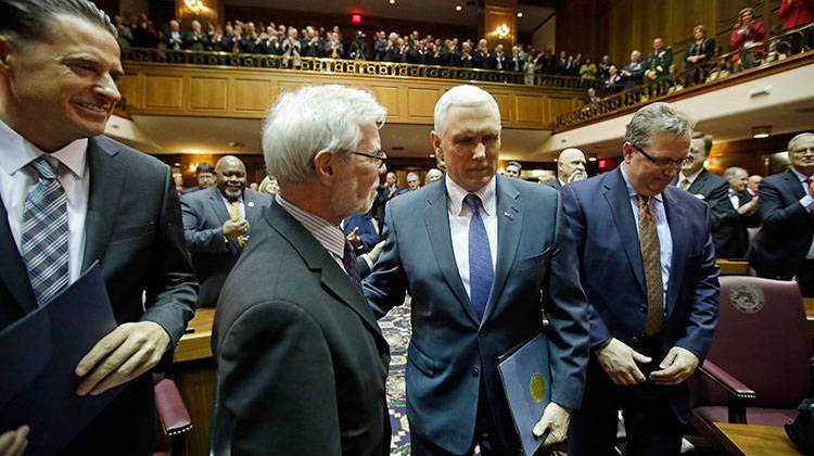 Indiana Gov. Mike Pence, second from right, walks to the podium to deliver his State of the State address to a joint session of the legislature at the Statehouse. - AP Photo/Darron Cummings