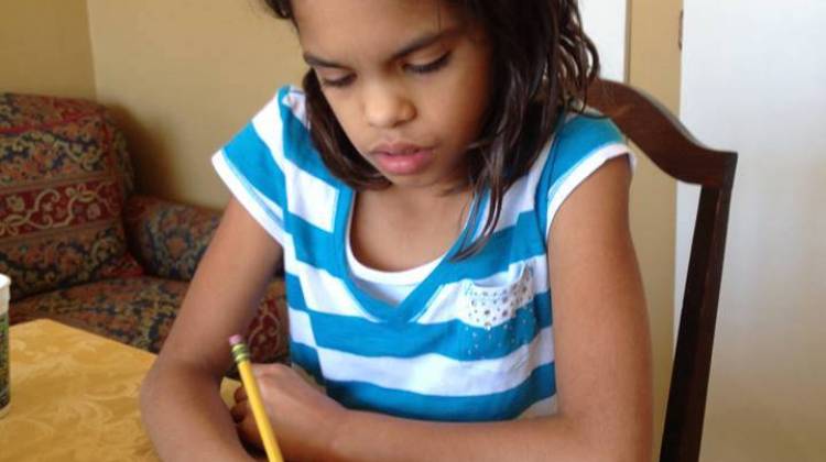 Fourth grader Isa Ruegger completes a page in her workbook at home. -  MaryAnn Schlegel Ruegger