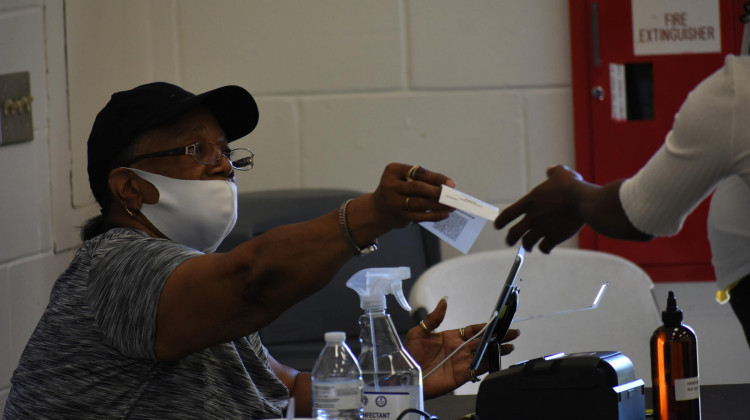 Poll workers and voters will have access to personal protective equipment at polling places this fall, like they did in the primary. The poll worker seen from June isn't wearing their mask correctly, blunting its effectiveness at halting COVID-19's spread. - Justin Hicks/IPB News