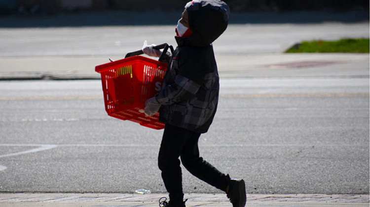A child walks from the grocery store in Gary with mask and plastic gloves on.  - Justin Hicks/IPB News