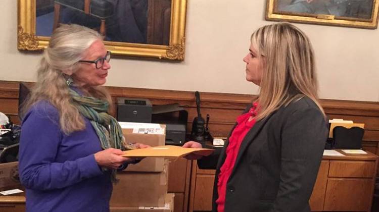 Dr. Leslie Bishop delivers a letter asking Gov. Holcomb to reduce logging on state land to Rebecca Holwerda, the governor's director of operations.  - Courtesy of Indiana Forest Alliance