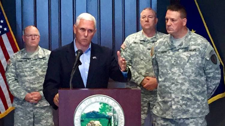 Gov. Pence, standing next to Adjutant General Courtney Carr, discusses the decision to arm National Guard members during a press conference Sunday, July 19, 2015 at Stout Field. - Brandon Smith / Indiana Public Broadcasting