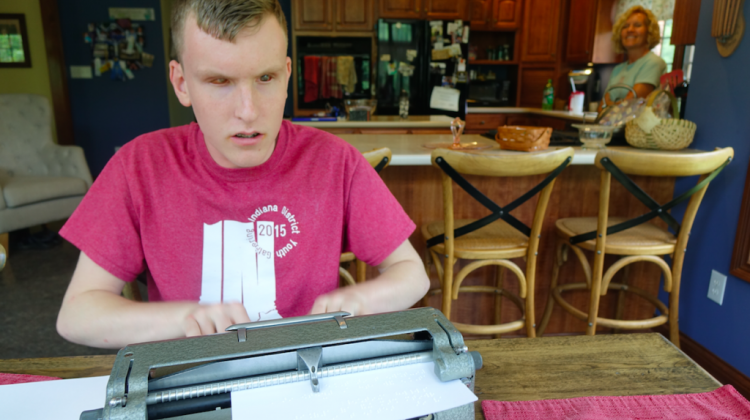 Mitchell Bridwell types on a Perkins Unimanual Brailler in the kitchen of his Pittsboro home as his mother Marta stands in the back, on Wednesday, June 14, 2017. Bridwell, 16, is one of 10 students from the U.S. and Canada to compete in the national Braille Challenge for his age group in Los Angeles on June 17, 2017. - Eric Weddle/WFYI Public Media