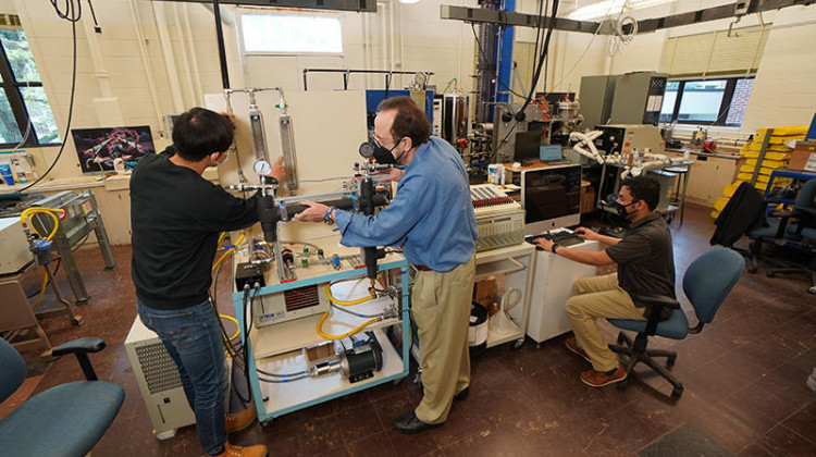Purdue University Professor Issam Mudawar (center) working with students in his lab on their new charging cable design. - (Jared Pike/Purdue University)