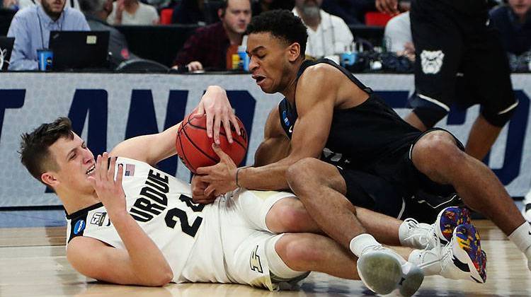 Purdue forward Grady Eifert (24) and Butler guard Aaron Thompson chase the loose ball during the first half of a second round game in the NCAA college basketball tournament, Sunday, March 18, 2018, in Detroit. - AP Photo/Carlos Osorio