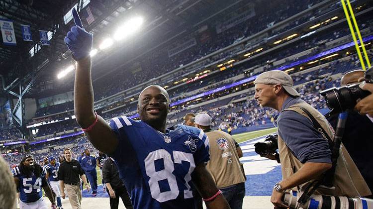 Former Indianapolis Colts wide receiver Reggie Wayne, center, waves to fans as he leaves the field following a game in 2013. - AP Photo/AJ Mast