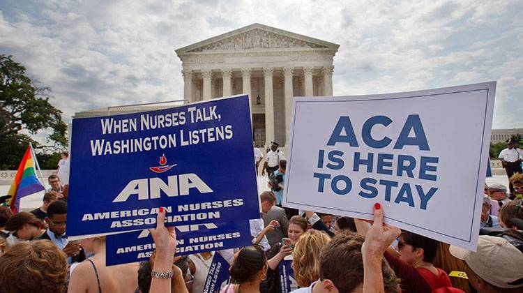 Supporters of the Affordable Care Act hold up signs as the opinion for health care is reported outside of the Supreme Court in Washington, Thursday June 25, 2015. The Supreme Court on Thursday upheld the nationwide tax subsidies under President Barack Obama's health care overhaul, in a ruling that preserves health insurance for millions of Americans. - AP Photo/Jacquelyn Martin