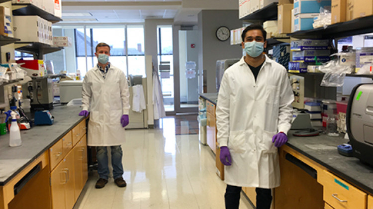 Laboratory technicians Justin Lange, left, and Akanksh Shetty observe social distancing while creating viral transport media at the University of Illinois. The fluid is used to preserve patient test samples for COVID-19. - Courtesy of Ann Hyoung Sook/University of Illinois