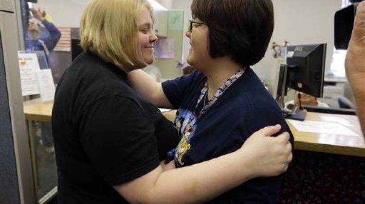 Katie Burris, left, and her partner Evangeline Cook embrace after receiving their marriage license at the Marion County Clerks office in Indianapolis, Monday, Oct. 6, 2014.