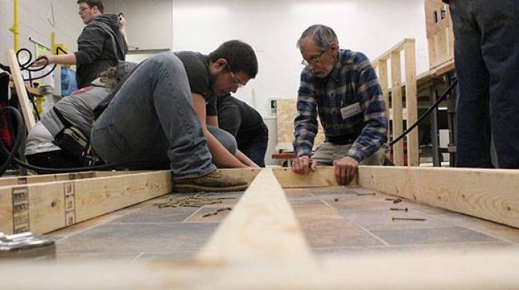 Ivy Tech students Riley Sullivan, left, and Arnold Dorey assemble part of an exterior wall during a class building simulation.  - Rachel Morello/StateImpact Indiana