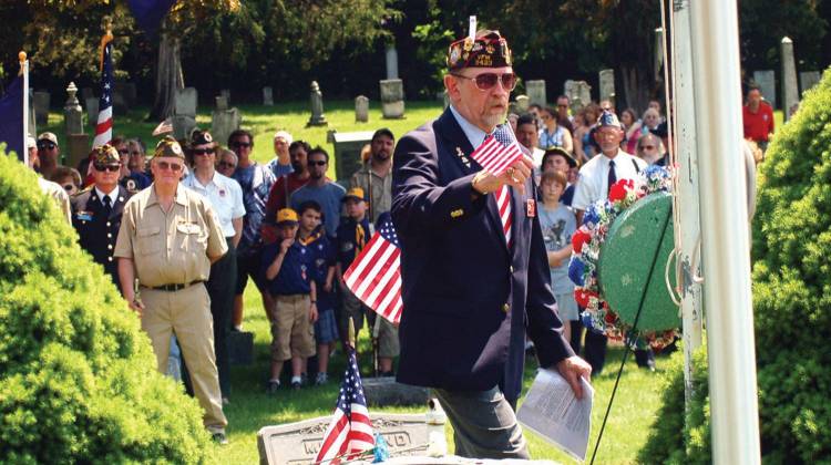 In this May 30, 2011 photo, Rich Mrozinski, Veterans of Foreign Wars commander for the Department of Indiana 3rd District, plants a flag during a Memorial Day ceremony at the Rolling Prairie, Ind., Cemetery.  - The Associated Press