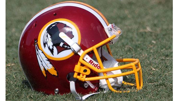A Washington Redskins football helmet lies on the field during NFL football practice. - Photo courtesy Keith Allison via Flickr