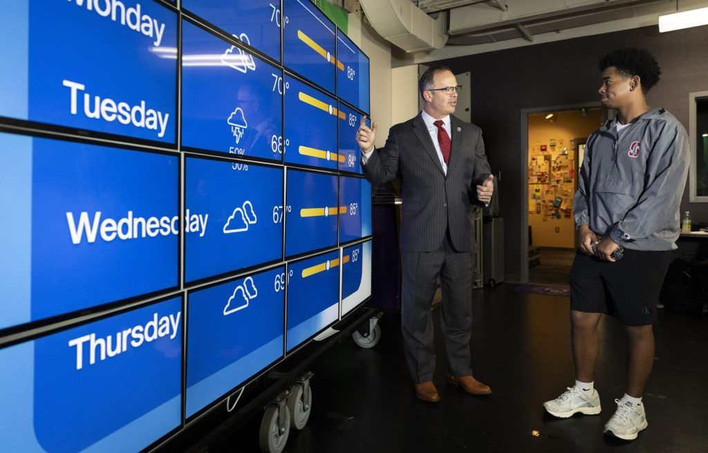 Wayne Township Superintendent Jeff Butts (left) looks at Quintin Gildon’s, 17, new setup for reporting the weather on Aug. 5, 2025, at Ben Davis High School’s broadcast studio in Indianapolis.