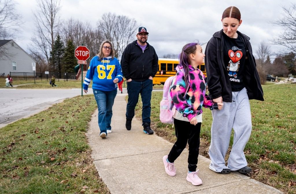 Josslynn Beattey, 8, holds hands with her sister, Maddie, 14, while walking home from the bus stop on Jan. 9, 2026, on their subdivision in Indianapolis.